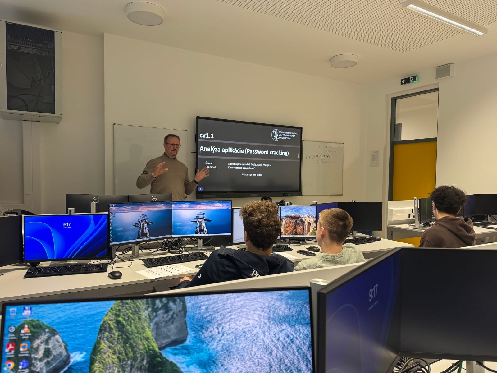 Počítačová laboratoř s výukou analýzy aplikací a prolomení hesel, studenti pozorně sledují lektora.